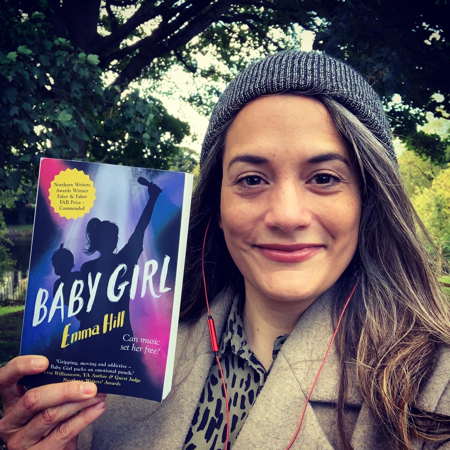 Emma Hill holding a copy of her book, Baby Girl